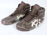une paire de baskets marron et blanches avec des touches de rouge sur un fond blanc
