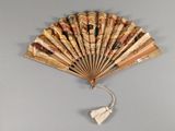 a fan with a picture on it hanging on a wall