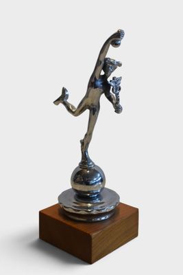 statue of a woman holding a tennis racquet on a wooden base