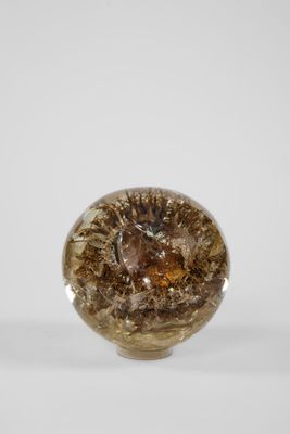 une image montrant un gros plan d'un objet en verre posé sur une surface blanche
