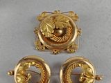 deux broches dorées et une paire de boucles d'oreilles