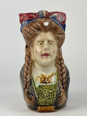 a ceramic figurine of a woman with braid hair