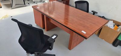 a wooden table with a black chair and a black chair in front of it