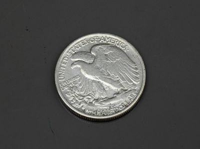 un gros plan d'une pièce de monnaie posée sur une surface noire, sur fond blanc