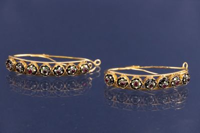 deux paires de boucles d'oreilles en or ornées de pierres multicolores sur un fond bleu