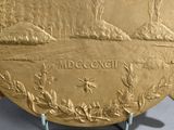 a gold plate with a picture of a landscape on it