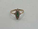 a close up of a gold ring with a green stone