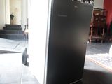 an image of a black refrigerator in a living room
