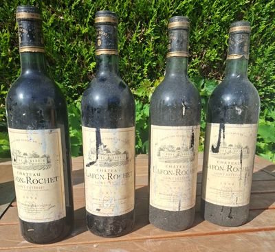 four bottles of wine are lined up on a wooden table