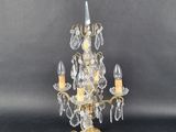 an image of a gold and crystal chandelier with two candles