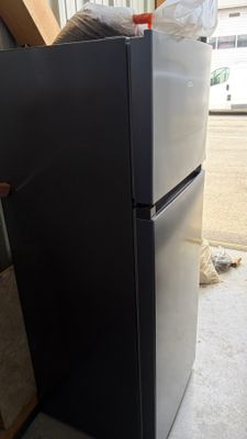 a black refrigerator sitting in the middle of a room