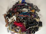 a pile of assorted jewelry on a white surface