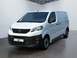 La petite camionnette blanche est garée dans une grande pièce.