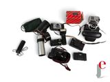 many different cameras and accessories laid out on a white surface