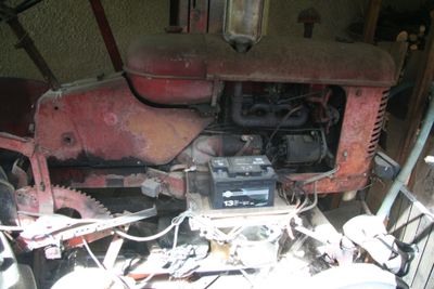 un tracteur rouge garé à l'intérieur d'un bâtiment