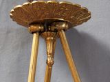 a gold lamp hanging from the ceiling on a tripod