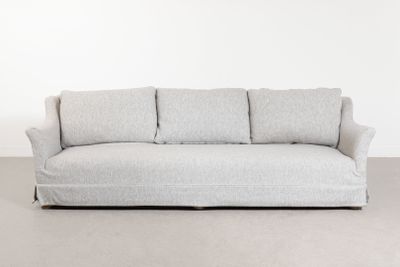 une photo d'un canapé blanc posé sur un sol recouvert de moquette