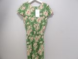 a green and pink floral dress hanging on a hanger