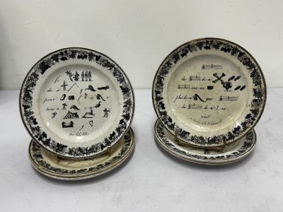 two black and white plates with writing on them sitting on a table