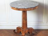 une photo d'une table au plateau en marbre posée sur un parquet