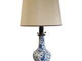 a blue and white vase with a lamp on it