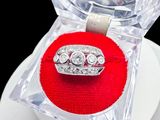 a diamond ring in a clear box on a red cushion