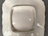 a white square plate with a square bowl on it