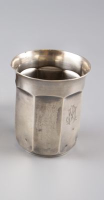 une paire de tasses argentées posées sur un support blanc