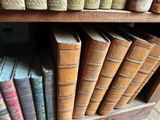 many old books on a shelf in a library