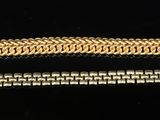 a close up of two gold bracelets on a black surface