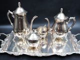 a silver tray with a silver tea set on it