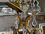 a gold chandelier with crystal drops hanging from it