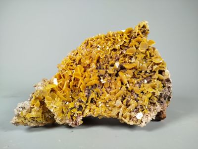 a close up of a piece of rock with yellow crystals on it
