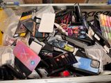 many cell phones in a metal container on the table