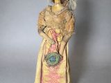 an image of a doll with a hat and a purse on a stand