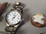 a silver watch sitting on a table next to other items