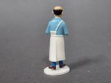 a small figurine of a man in a blue shirt and white apron