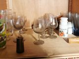 many wine glasses sitting on a shelf in the kitchen
