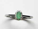 Gros plan sur une bague ornée d'une pierre verte