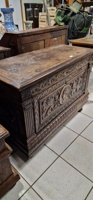un grand coffre en bois posé par terre dans un magasin