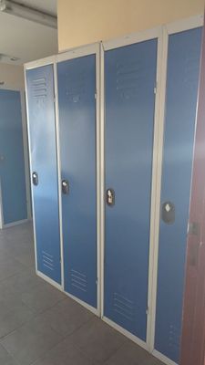 Plusieurs casiers bleus sont alignés dans le couloir d'un immeuble