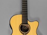 On voit une guitare acoustique sur fond gris.