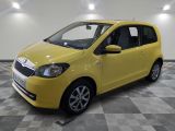 the small yellow car is parked on a checkered floor