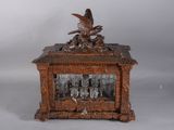 une horloge en bois surmontée d'un oiseau