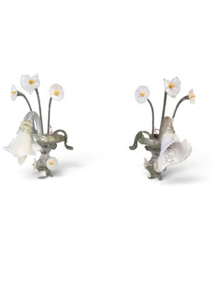 two figurines of flowers are sitting next to each other on a white surface