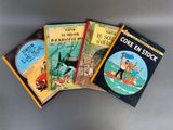 Quatre livres pour enfants sont alignés sur une surface grise