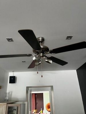 un ventilateur de plafond suspendu au plafond d'une pièce