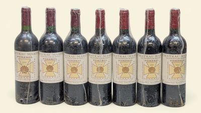 six bouteilles de vin alignées sur une surface blanche