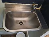a stainless steel sink in the corner of a room