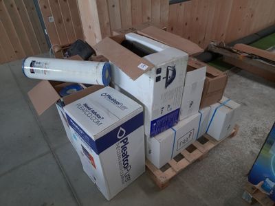 une pile de cartons et un rouleau de ruban adhésif posés sur une palette